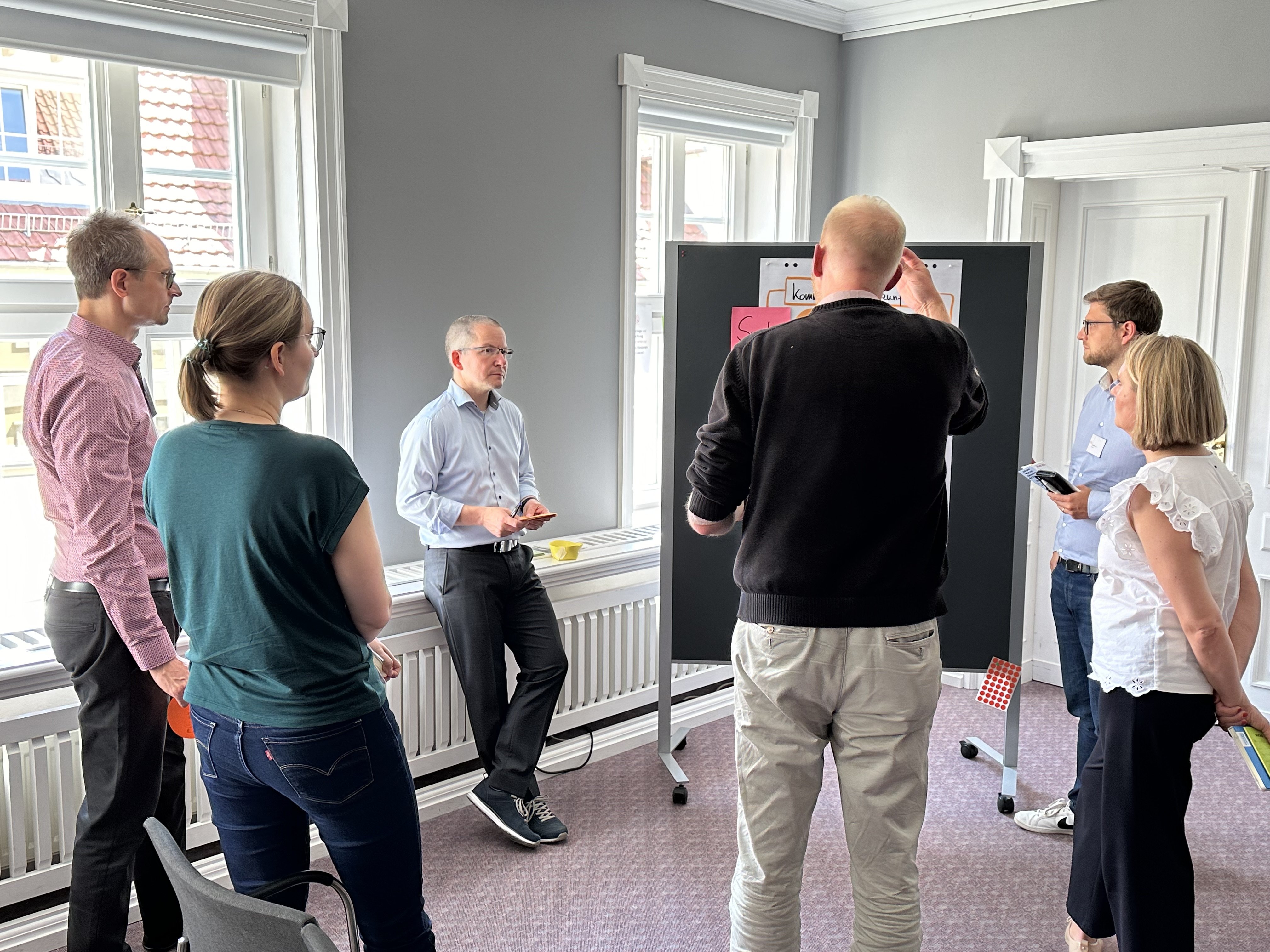 Menschen stehen um ein Flipchart herum